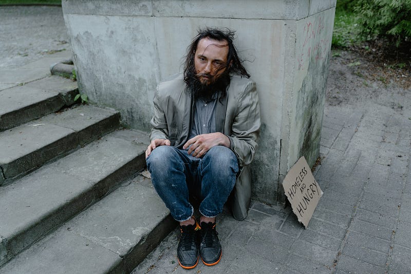 A homeless man sitting on the street