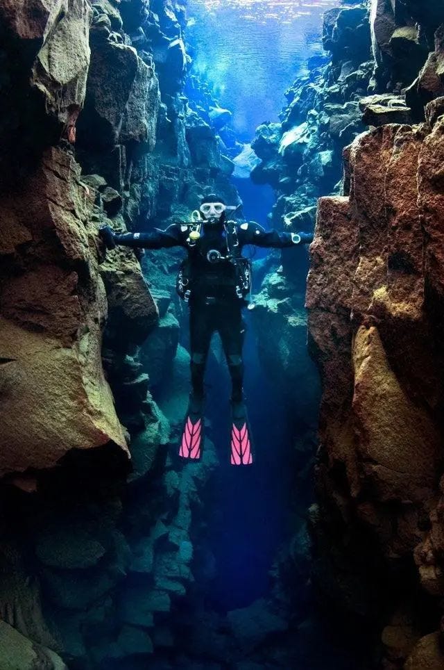 Diver touching tectonic plates in Iceland